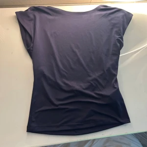 Mörkblå topp från Stradivarius - Den är i M men passar även S och använd runt 2 gånger. En stilren mörkblå topp från Stradivarius i mjukt och stretchigt material. Toppen har korta ärmar och en enkel, figurnära passform med rund halsringning. Perfekt att matcha med jeans eller kjol för en clean look.🥰🥰