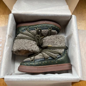 Gröna Inuikii boots med fårull - Säljer ett par Inuikii boots i grönt skinn med beige fårull och grova snören. Skorna är slutsålda då de köptes förra vintern. Har använt de en gång ute men inget som syns alls vilket man kan se på bilderna, så helt som nya. Köptes på miinto för 3 999kr. Kommer ej gå ner i pris då de är helt nya och inte går att få tag på längre.