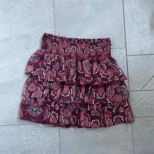 Vinröd volangkjol med mönster - Supersöt kort volangkjol i vinrött.