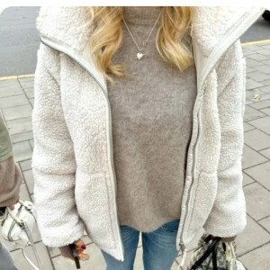 Vit teddyjacka - Mysig vit teddyjacka med hög krage och dragkedja framtill. ❤️Jackan har två stora fickor och är tillverkad i ett fluffigt teddy-material som håller dig varm. Perfekt för kyliga dagar och ger en trendig look till jeans eller andra outfits. Perfekt nu till hösten om man vill ha en mysig och kön loock!😍 