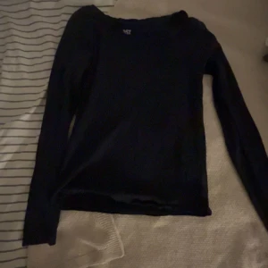 Svart långärmad tröja från 157 - En enkel svart långärmad tröja från 157 med rund hals. Perfekt för lager-på-lager och passar till jeans eller kjol. Mjuk och skön känsla, stilren design utan detaljer eller mönster.