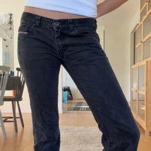 Svarta bootcut jeans från Diesel - Snygga svarta Diesel Doozy jeans med bootcut passform och låg midja. Jeansen är i stretchigt denim som sitter skönt och har klassiska fem fickor samt diskreta detaljer. Perfekta för dig som gillar en avslappnad men ändå stilren look.