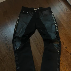 Svart läder denim jeans diy  - Diy jeans med detaljer både på baksidan and fram.  Mått: 102 cm lång - 43 cm midja - 22 cm ved öppning 