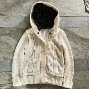 Cardigan med päls - Stickad cardigan med päls! St S men passar även XS! Passar perfekt nu till hösten/vintern! Obs saknar knappen längst ner skulle dock säga att det inte stör när man har på sig den! Hör av dig vid ytterligare frågor! Mvh Henry 