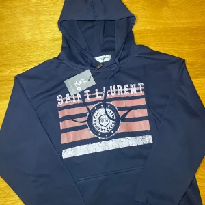 Saint Laurent huddie  - Marinblå Saint Laurent hoodie. Är storlek L men sitter som M, den är ganska liten i storlek. Bara att skriva vid funderingar 