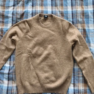Beige kashmirtröja från Uniqlo - Mysig beige tröja från Uniqlo i kashmir med rund halsringning och lång ärm. Fick ett litet hål bakifrån men fixade det.