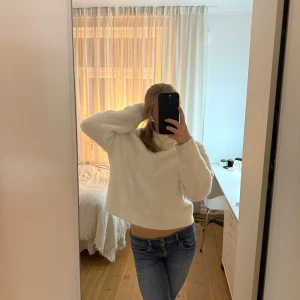 Vit polotröja från Kappahl i S - Mysig vit polotröja från Kappahl i storlek S. Tröjan är fluffig och har en croppad passform med lång ärm och hög krage. Perfekt för kalla dagar och enkel att matcha med jeans eller kjol. Materialet är mjukt och stickat för extra komfort.