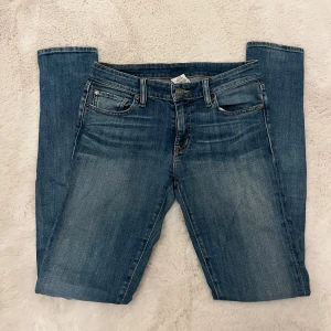 Blå Ralph Lauren  jeans straight fit - Klassiska blå Ralph Lauren jeans med straight fit och snygga slitningar framtill. Jeansen har fem fickor, gylf med dragkedja och bruna kontrastsömmar. Perfekta för en avslappnad och stilren look.