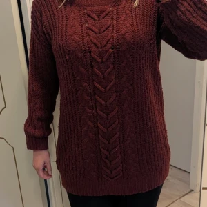 Vinröd stickad tröja från Sister - Stickad längre tröja i storlek L. Finns lite slitningar och noppor, främst på armarna och längst ner på mudden. Är hel och fläckfritt och i övrigt bra använt skick.