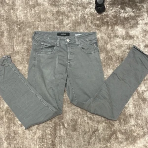 Replay Grover grå jeans - Snygga grå jeans från Replay, modell Grover. Klassisk femficksdesign med Replay-logga på fickan och bak på linningen. En liten fleck på baksidan.