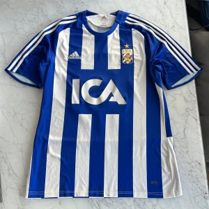 IFK Göteborg matchtröja Adidas blå/vit - Säljer en klassisk IFK Göteborg fotbollströja från Adidas från säsong 2008/2009. Tröjan är i lätt och ventilerande ClimaCool-material och har korta ärmar samt rund hals. Kom gärna med prisförslag!