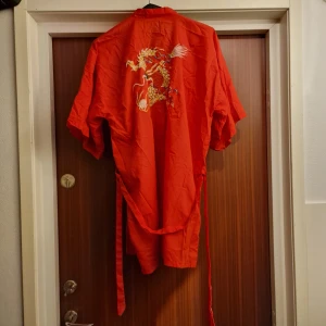 Röd kort kimono med sjukt snygg drake bak på ryggen. Knytning i midjan. - Röd kort kimono med sjukt snygg drake bak på ryggen. Knytning i midjan.  