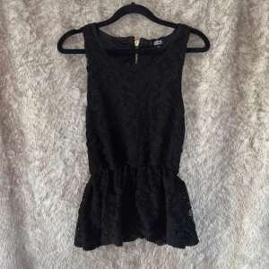 Svart spetstopp från bikbok xs - Supersöt svart spetstopp med guldig dragkedja bak. Resår i midjan och volanger nertill. Tyget har lätt att noppra sig.