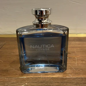 Nautica Voyage fräsch parfym - Stilren parfym med blått innehåll från Nautica. Perfekt för dig som vill ha en modern och fräsch känsla. Flaskans design är enkel och passar in i alla badrum. Namnet 'Voyage' ger vibbar av äventyr och frihet.