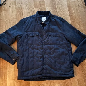 Mörkblå quiltad overshirt från Solid - Quiltad mörkblå overshirt från Solid Denmark i storlek XL. Lite dun kommer ut lite här och vart men annars inget problem