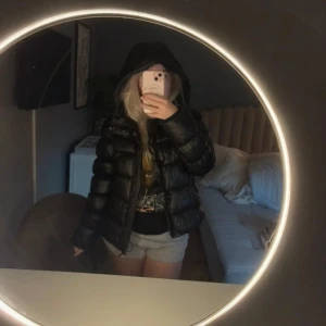 Svart pufferjacka från XP-D - Säljer en svart pufferjacka från XP-D ( superdry) med glansig finish och stor huva. Jackan har quiltad design, dragkedja framtill och säljer för att jag ska köpa en annan ❤️storlek 38. Köpt för 1000 , säljer för 800 prutbart!