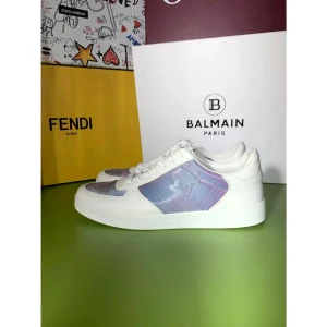 Louis Vuitton sneakers - Säljer ett par exklusiva Louis Vuitton sneakers i vitt skinn med lila, skimrande paneler och klassiskt LV-monogram. Skorna har snörning och rund tå, samt en platt sula för en clean look. Perfekta för dig som vill sticka ut med lyxig streetstyle.