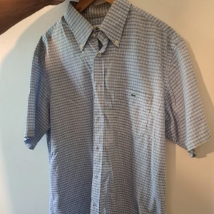 Blårutig kortärmad skjorta Lacoste - Blårutig skjorta från Lacoste med korta ärmar och klassisk krage. 