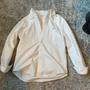 Vit Ralph Lauren skjorta  - Säljer en vit Ralph Lauren skjorta i storlek 14-16 barn men passar även XS. Bra skick, inga hål eller slitningar