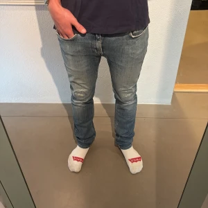 Blå Acne Studios jeans med slitningar - Säljer ett par blå jeans från Acne Studios med snygga slitningar på knäna. Jeansen är slim fit och strl 33