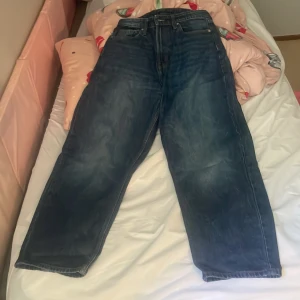 Levi's 501 blå jeans loose fit - Klassiska Levi's 501 jeans i mörkblå denim med raka ben och loose fit. Byxorna har fem fickor, knappgylf och hög midja. Perfekta för en avslappnad och trendig stil.