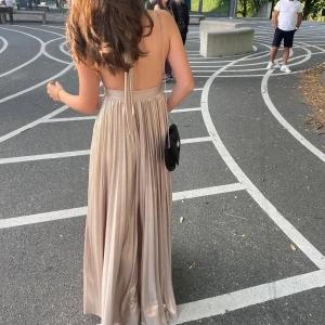 Champagnefärgad balklänning med öppen rygg - Säljer min balklänning efter användening en gång💞Tveka inte om att höra av er om frågor eller priset. 