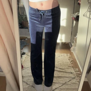 Mörkblå mjukisbyxor med snörning från Gina Tricot - Säljer ett par mörkblå mjukisbyxor i mjukt och skönt material med snörning i midjan. Byxorna har rak passform och sitter högt i midjan, perfekta för chill dagar eller när du vill vara extra bekväm. Passar dig som gillar loose fit och stilren look.