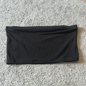 Svart topp - Säljer denna svarta topp från Lindex då den är för stor. Går även att använda som mini kjol. Aldrig använt.