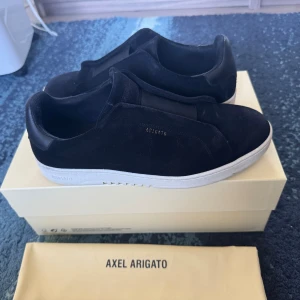 Svarta sneakers från Axel Arigato - Säljer mina arigato skor som jag köpte för 2 veckor sen. Säljer dom pga att jag fick ett par gråa arigatos . Dom ser helt nya ut sulan är fortfarande helt vit. Nypris 3000kr, passa på köp!!
