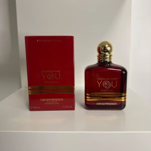 Emporio Armani Stronger With You Tobacco - Emporio Armani Stronger With You Tobacco är en exklusiv parfym i en djup röd glasflaska med gulddetaljer och rund guldfärgad kork. Doften är intensiv och elegant, perfekt för dig som gillar unika och lyxiga parfymer. Flaskan rymmer 100 ml Eau de Parfum.
