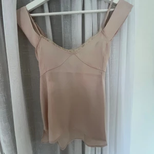 Gulligt linne från Ark & Co - Säljer en ljusbeige linnetopp från Ark & Co med smala axelband och v-ringning dekorerad med spets. Går att ha som både nattlinne, till vardags och till finare tillfällen🤎🤎🤎