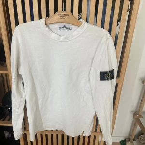 Stone Island Vit Tröja  - Vit långärmad tröja från Stone Island med den ikoniska kompassen på vänster ärm. Tröjan är i fint skick och är inte särskilt använd. Storlek small. 