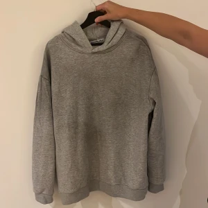 Grå hoodie Acne Studios Stockholm - Snygg grå hoodie från Acne Studios med tryck på ryggen: 'Acne Studios STOCKHOLM 1996'. Klassisk passform med huva och långa ärmar. Perfekt för en chill och stilren look. Mjuk och skön i bomullsmix. Nypris 5300 Öppen för bud