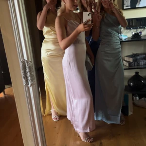 Ljuslila långklänning i satin - Säljer en superfin ljuslila långklänning i satin med smala axelband och snygg drapering vid bysten. Klänningen är andvänd en gång på lärarmiddagen. Klänningen är som ny och har inga fläckar.