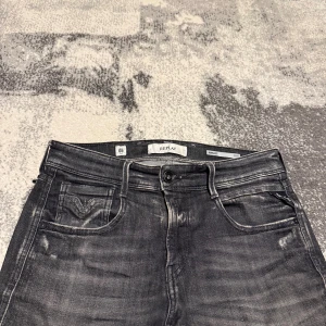 Replay Anbass Jeans Slitningar - Snygga svarta Replay Anbass jeans med slitna detaljer i den eftertraktade modellen (aged eco 05). Tillverkas inte längre och därav väldigt eftertraktad. Nypriset låg på 1899kr. Jeansen är i toppskick.