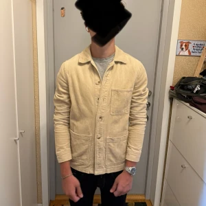 Beige manchester overshirt Studio Total - Säljer en beige overshirt från Studio Total i manchester. Jackan har tre stora fickor framtill, knäppning med knappar och klassisk krage.