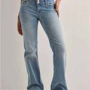 Ljusblå bootcut jeans - Säljer ett par ljusblå jeans från Nelly med bootcut-modell och snyggt broderade bakfickor. Jeansen är låg midja de och är perfekta för dig som gillar en avslappnad men trendig look.💗