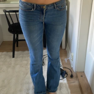 Blå bootcut jeans från Levi's - Snygga blå jeans med klassisk bootcut passform. Jeansen har normal midja, fem fickor och stängs med dragkedja och knapp. Perfekta för dig som gillar en tidlös och avslappnad stil.