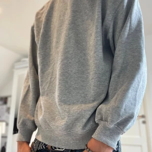 Grå sweatshirt från H&M Divided - Enkel och stilren grå sweatshirt från H&M Divided. Tröjan har rund hals, ribbade muddar och är tillverkad i mjuk bomullsmix. Perfekt för en chill och avslappnad look. Passar dig som gillar basic och bekvämt. Storlek S😄