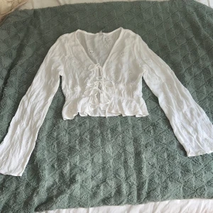 Vit blus med snörning från FB Sister - Superfin vit blus från FB Sister i storlek S. Blusen har långa ärmar, v-ringning och snörning framtill. Tröjan är använd en gång säljer då den är lite liten för mig 