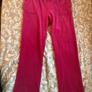 röd rosa Juicy Couture - Ett par mycket fina röd/rosa juicy byxor i strlk M. Dessa byxor har används fåtal gånger då jag inte har tyckt om dom.   Skriv om intresserad💗 