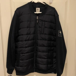 Garcia cardigan - Svart pufferjacka från Garcia i storlek XL. Jackan har quiltad framsida, släta ärmar och ribbade muddar. Jackan passar också storlek M och L