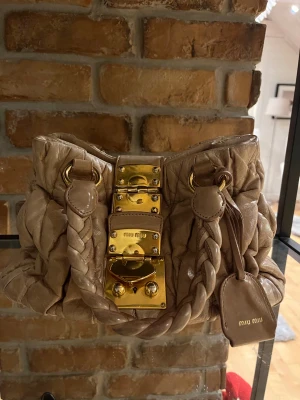 Miu Miu väska  - Säljare min älta miu miu väsla som jag köpte på A retro tale. Dust bag medföljer och ett kort på äkthet. Jätte fint sick och två nycklar med följer till låset 