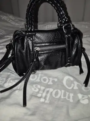 En så snygg Mini Bowlingväska från Bershka! Ser ut som en liten city bag! Använd mycket men fint skick! Inga defekter utom en tråd som sticker ut, ett pytteskav på ena sidan under men syns knappt. Även att lilla dragkedjan är dock seg, vet inte om den fastnat eller ska vara så. Ska rengöra insidan ännu mer och längre band följer såklart med! ❤️❤️