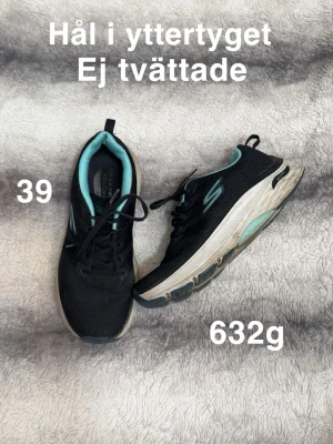 Svarta Skechers sneakers strl 39 - Svarta Skechers sneakers med turkosa detaljer och vit sula. Skorna har snörning och är tillverkade i mesh-liknande syntetmaterial. Sulan är extra tjock och har turkosa partier undertill. Perfekta för dig som gillar sportig stil.🌸Inte använda speciellt många gånger men blivit ett litet hål på yttertyget. ( ej rakt igenom). Ej tvättade. Storlek 39