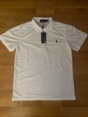 Ralph Lauren piké - Säljer en fin Raulph lauren piké i färgen vit med den klassiska Ralph lauren loggan på bröstet den är en enkel och fin perfekt för en stilren klassisk look, Skriv om du undrar något 