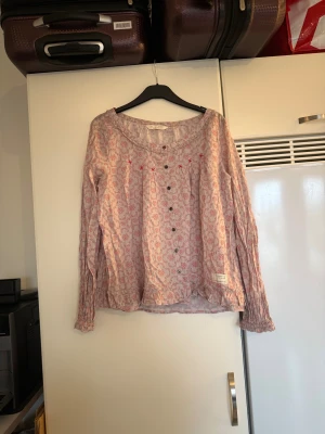 Odd molly blus  - Säljer en otroligt vacker blus i en ljuslil nyans men rosa blommiga detaljer i rosa. Från märket Odd Molly. Storlek 2 som enligt deras storleksguide motsvarar en M. Fint men den är mer använd. Se bild 3 för anmärkning. 