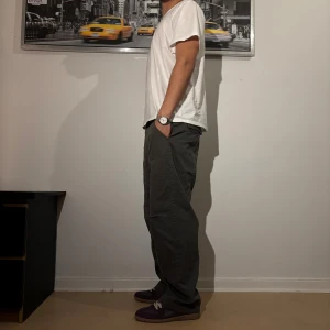 Mörkgröna cargopants med loose fit - Säljer ett par mörkgröna cargopants med avslappnad loose passform och raka ben. Byxorna har flera fickor och synliga sömmar som ger en cool och urban vibe. Perfekta för dig som gillar streetwear och vill ha bekväma byxor med lite extra edge.