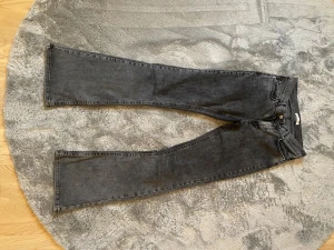 Svarta straight jeans från Gina Tricot - Snygga svarta jeans från Gina Tricot i storlek 38 låg midjade. Modellen har klassisk femficksdesign, raka ben och normal passform. Jeansen är tillverkade i ett mjukt denimtyg med lätt tvättad look och har knapp- och dragkedjestängning framtill.