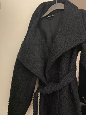 Marinblå teddykappa Gina Tricot - Mysig teddyjacka från Gina Tricot med bred krage och knytbälte i midjan.  Storlek xxs men jag e en S o den passar perfekt!  Kan även byta mott nått 